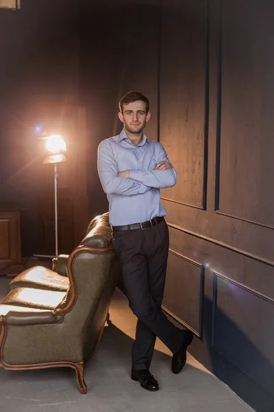 Gömlekli Gürcü bir adam eski bir sandalyede oturur.