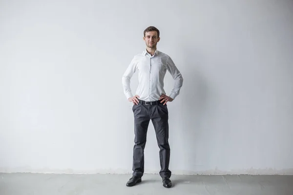 Beyaz duvarın yanında duran Gürcü öğretmen