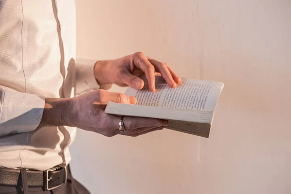 Man Standing White Wall Flipping Book — Stock Fotó