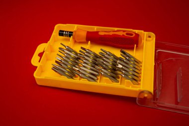 Screwdriver with small bits on a bright background