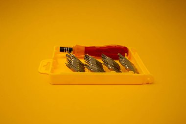 Parlak arkaplanda küçük parçaları olan tornavida