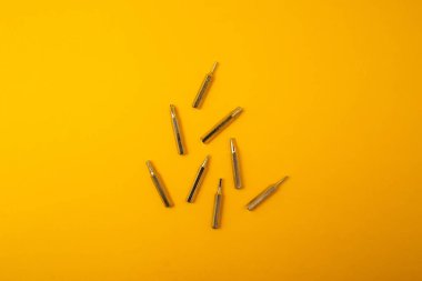 Sarı arkaplanda küçük tornavida parçaları