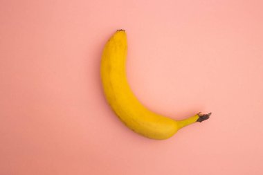 Bright yellow bananas on a pink background