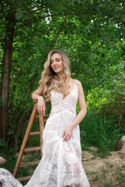A bride on a ranch in a white dress and boots