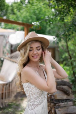 A bride on a ranch in a white dress and boots