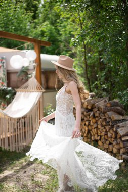 A bride on a ranch in a white dress and boots