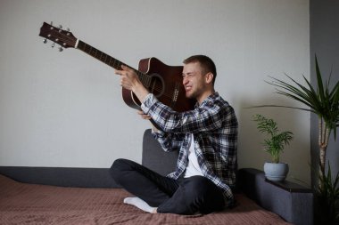 Bir adam gitardan silah taklit eder.