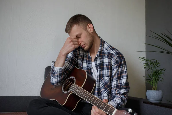 Bir adam bir gitar tutar ve düşünür