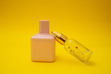 Pink bottle of perfume on a yellow background