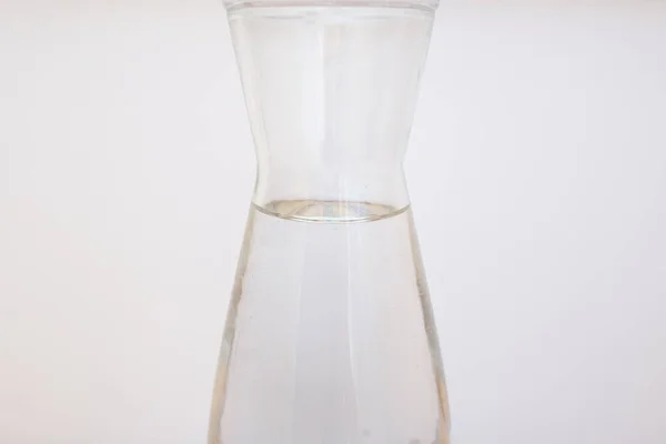 Glass carafe of water on white background