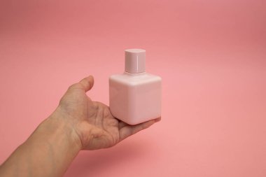 A girl touches a bottle of perfume