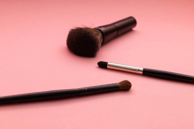 pembe arka planda makyaj fırçaları