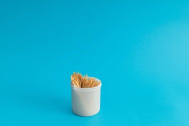 Mavi arka planda bir kavanozda diş fırçaları