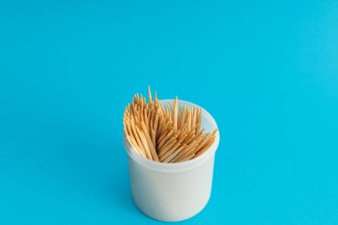 Mavi arka planda bir kavanozda diş fırçaları