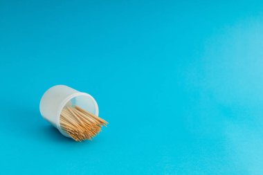 Mavi arka planda bir kavanozda diş fırçaları