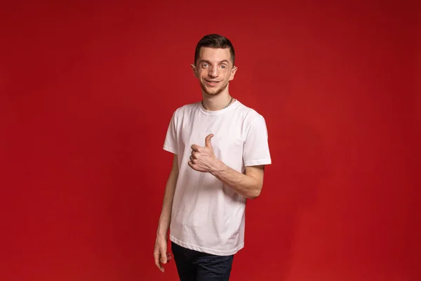Ung Man Vit Shirt Står Röd Bakgrund Och Ler Medan — Stockfoto