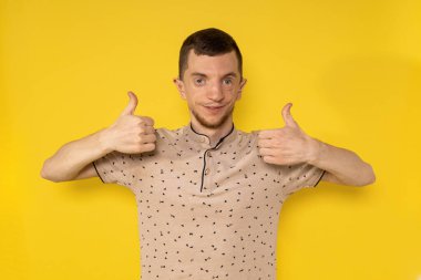 Sarı arka plandaki adam parmağını kaldırıyor.