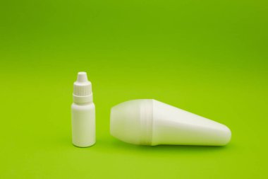 Beyaz deodorant ve parlak yeşil arka planda beyaz şişe.