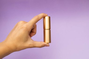 Bir kız elinde altın bir şişe tutuyor.