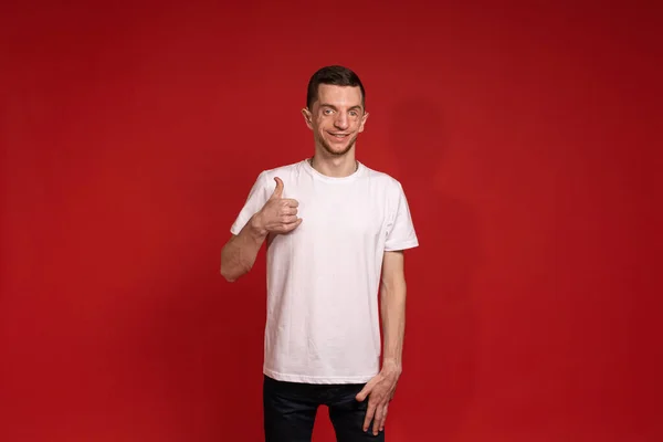 Ung Man Vit Shirt Står Röd Bakgrund Och Ler Medan — Stockfoto