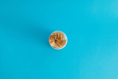 Mavi arka planda bir kavanozda diş fırçaları