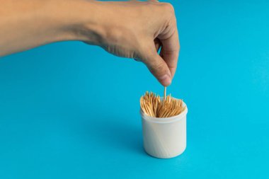 Mavi arka planda bir kavanozda diş fırçaları