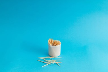 Mavi arka planda bir kavanozda diş fırçaları