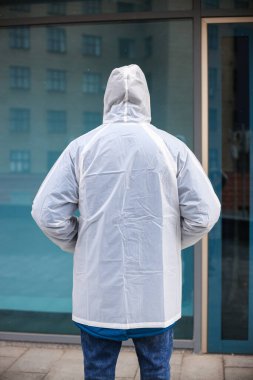 Dışarıda ateş eden bir adama yağmurluk.