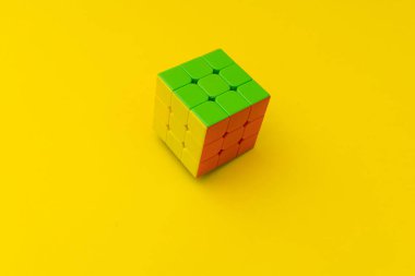 Sarı arkaplanda parlak rubik küpü, renkli fotoğraf