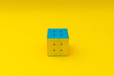 Sarı arkaplanda parlak rubik küpü, renkli fotoğraf