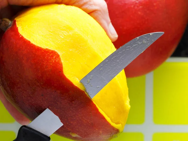 Mango yemek için hazırlanıyor. Bıçak meyveyi soyar. Sağlıklı yemek.