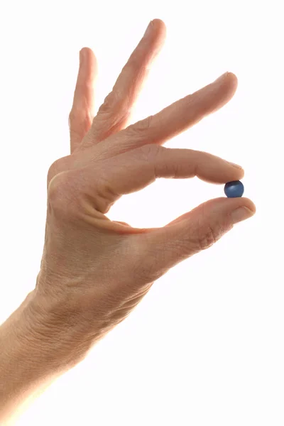 Blue pill held between fingers. medicine concept — Stock Photo, Image