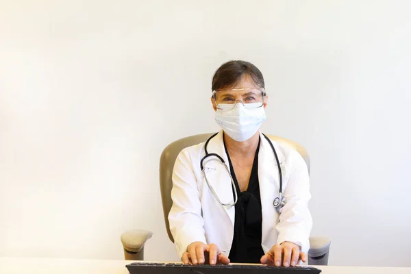 Maske ve gözlük kullanan kadın doktor.