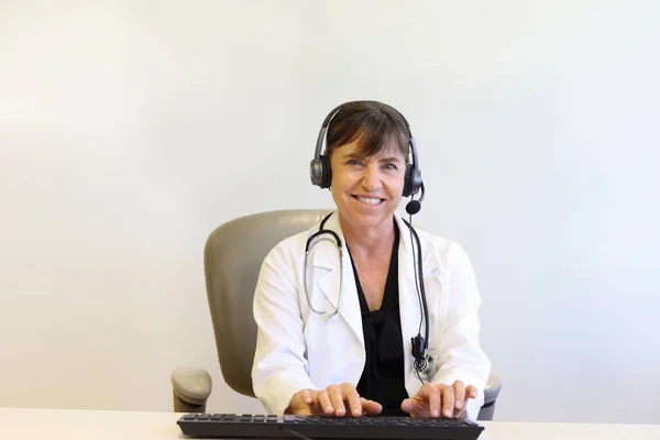 Teletıp seansında kulaklıkla orta yaşlı kadın doktor sohbetleri.