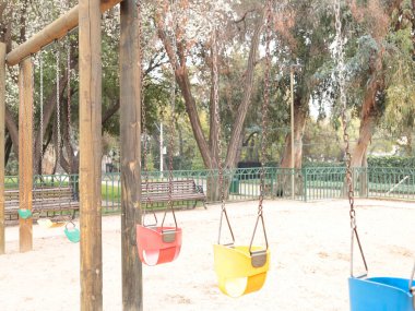 Pretty colorful empty swings in a park, without people