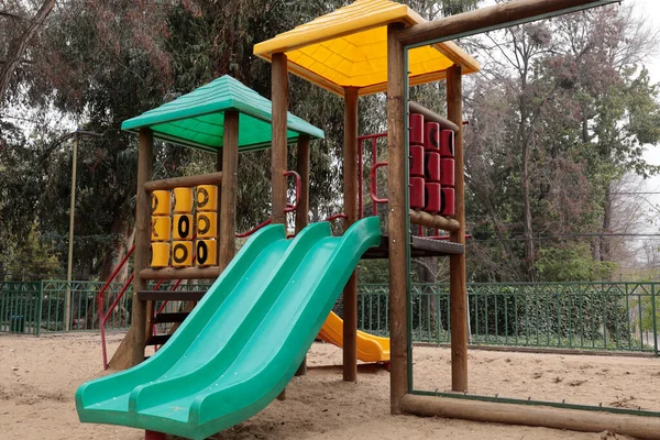 childrens playground with slides and stairs on a cloudy day in a city park