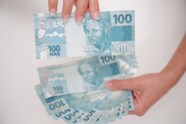 Siyah cüzdan ve mavi el ile 100 reais banknot.