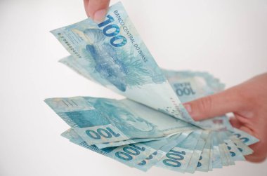 Siyah cüzdan ve mavi el ile 100 reais banknot.