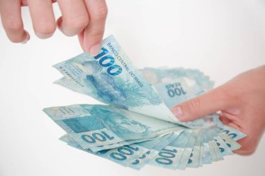 Siyah cüzdan ve mavi el ile 100 reais banknot.