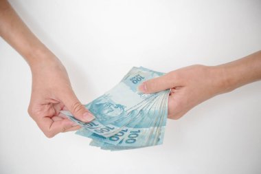 Siyah cüzdan ve mavi el ile 100 reais banknot.