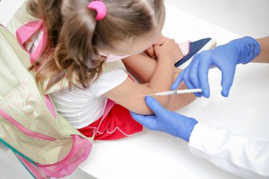 Covid 19 'a karşı aşılanan çocuk mavi eldiven ve şırıngayla tıp fakültesine geri dönüyor..