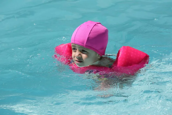 Niño Piscina Nadando Con Flotador Rosa Con Agua Azul —  Fotos de Stock