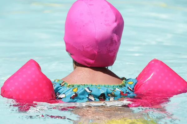 Barn Poolen Svømning Med Lyserød Flyde Med Blåt Vand - Stock-foto