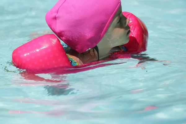 Dziecko Basenie Pływanie Różową Platformą Niebieską Wodą — Zdjęcie stockowe