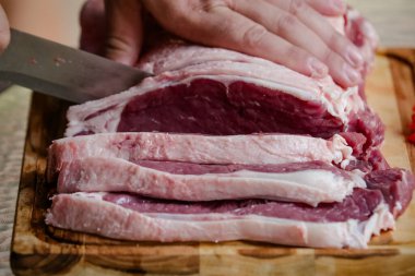 Arka planda keskin bıçakla masada sığır eti kesiyor..