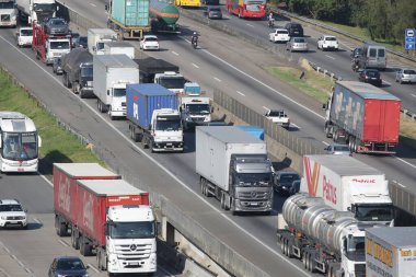 Otoyoldaki arabalar ve kamyonlar günlük kargo taşımacılığı yapıyor..