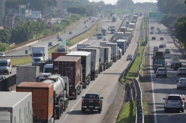 Otoyoldaki arabalar ve kamyonlar günlük kargo taşımacılığı yapıyor..
