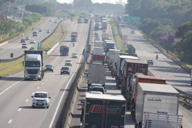 Otoyoldaki arabalar ve kamyonlar günlük kargo taşımacılığı yapıyor..