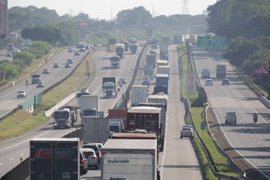 Otoyoldaki arabalar ve kamyonlar günlük kargo taşımacılığı yapıyor..