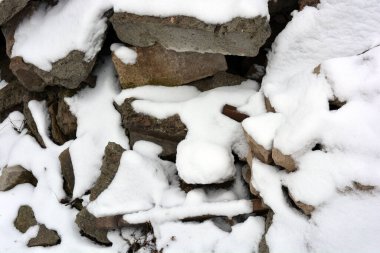 İnşaat malzemelerinden, tuğlalardan, çimento bloklarından oluşan bir dağ, gri kenar kaldırımlı metal parçaları, çöpler, kışın güzel beyaz kar kaplamalarıyla kaplı çöpler.. 